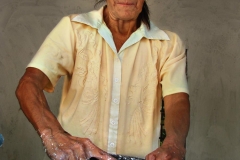 Dionora's mom rolls tortillas on a traditional stone block in El Salvador