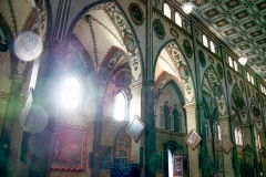 Sun beams through the stained glass windows Inside the Iglesia de Banos in Banos, Ecuador