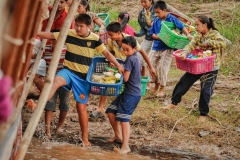 Children jump onto a touristic long boat to sell food and drinks to the passengers during a Mekong River cruise