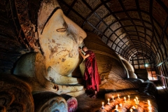 A monk prays by candlelight in a temple in Bagan, Myanmar