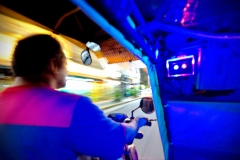 A tricycle driver covers his vehicle in neon for night drives through Manila