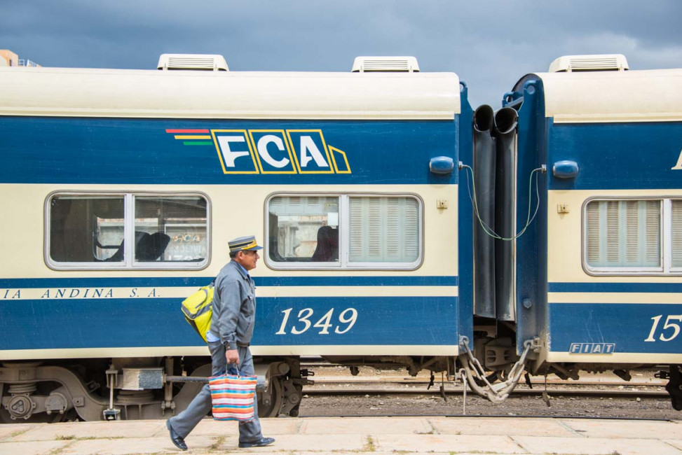 A train employee walks past a FCA car at the Oruro station in Bolivia