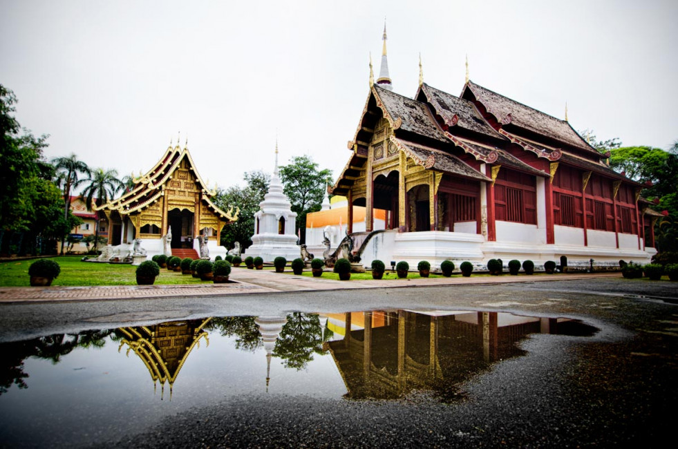 Wat Phra Singh reflects in a puddle during an early morning visit