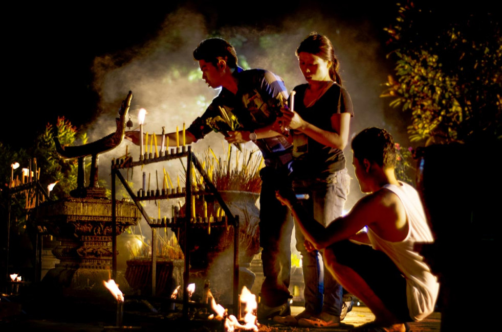 Locals light prayer candles to honor Buddha during Asanha Bucha Day in Chiang Mai