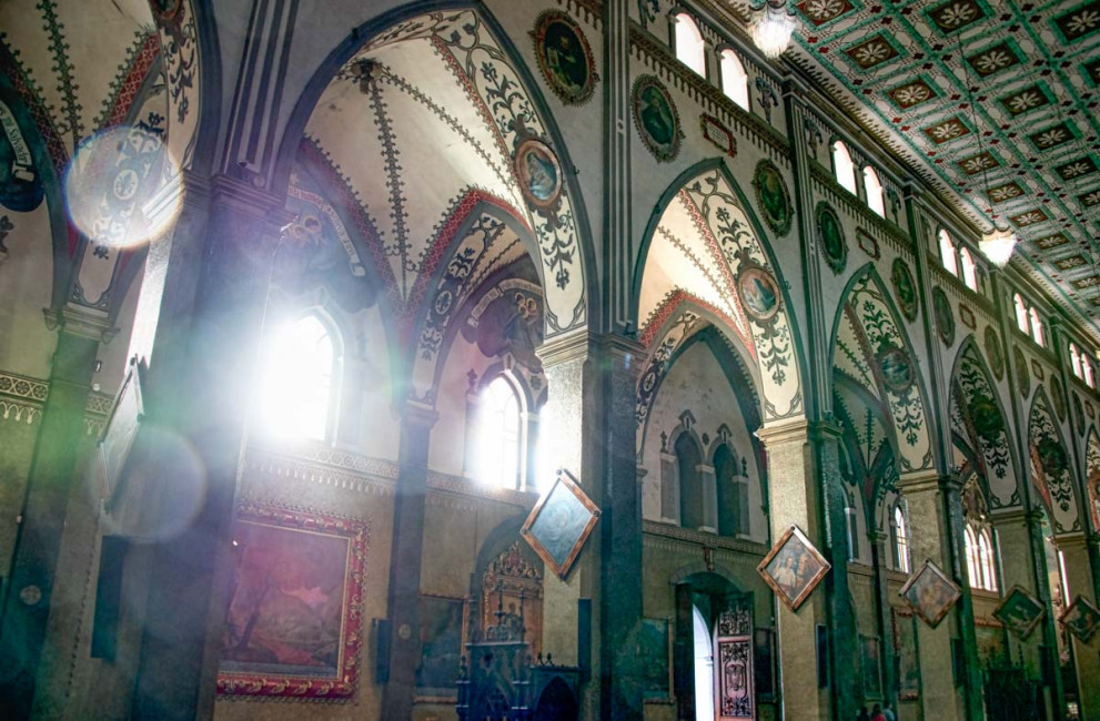 Sun beams through the stained glass windows Inside the Iglesia de Banos in Banos, Ecuador