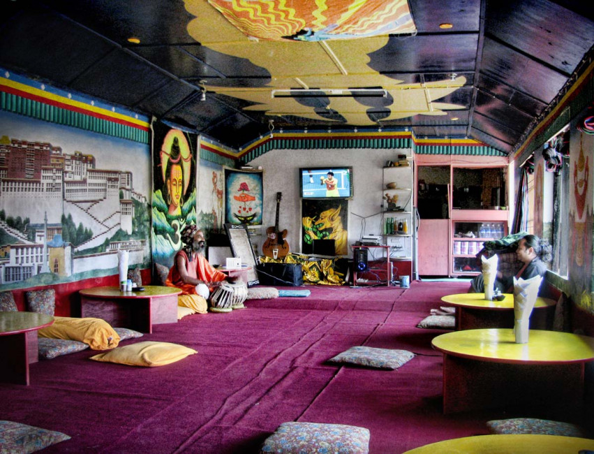 A baba plays a table inside a touristic restaurant in Bhagsu, India