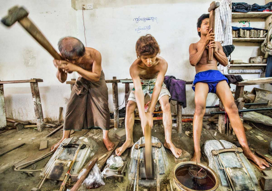 Workers pound gold leaf at the Golden Rose in Mandalay, Myanmar (Burma)