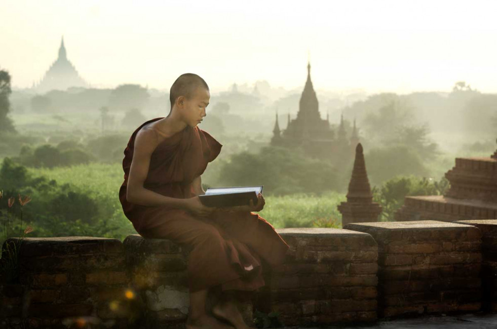 A monk reads a book at sunrise at the Shwe Nyen Yin Myaw Temple in Bagan, Myanmar (Burma)