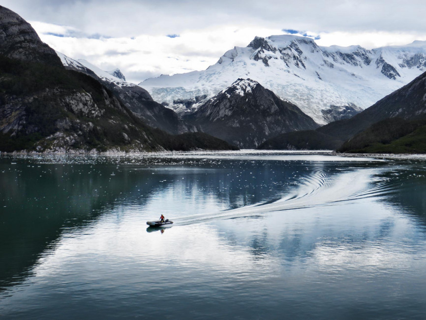 A zodiac boat glides through the Beagle Channel, alongside the Pia Fjord and Glacier in Patagonia, Chile