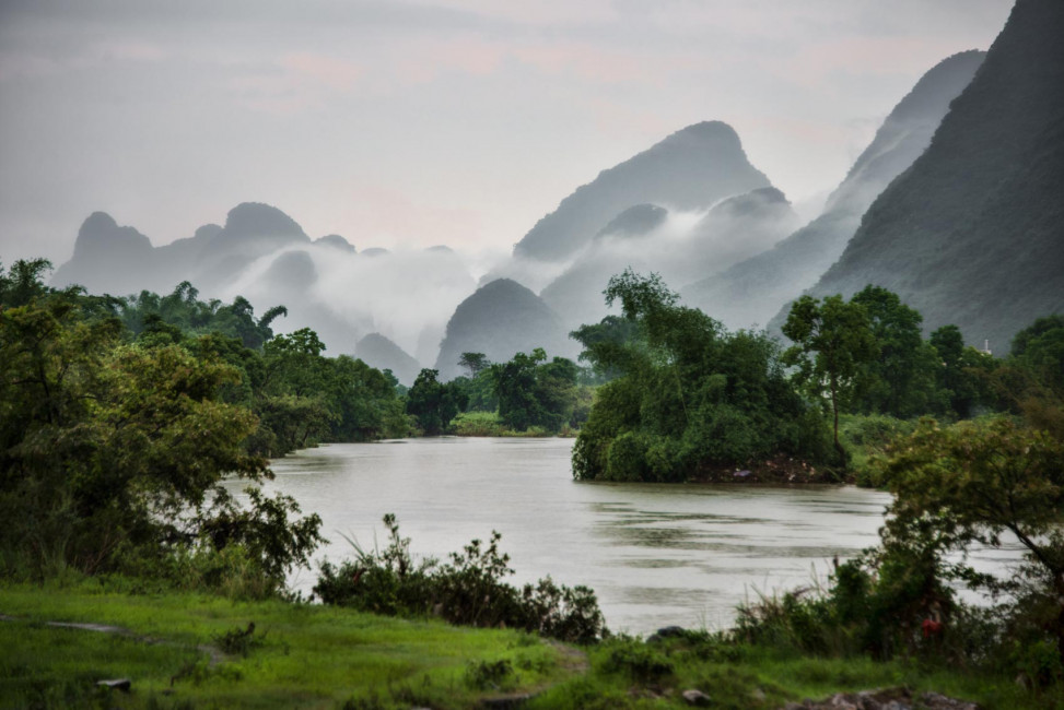 Majestic karsts surround a foggy day along the Yulong River in Yangshou, China