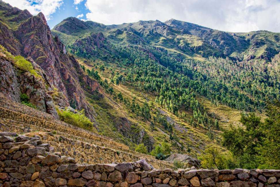 The Ollantaytambo ruins sit alongside beautiful mountains and lush greenery in the Sacred Valley of Peru