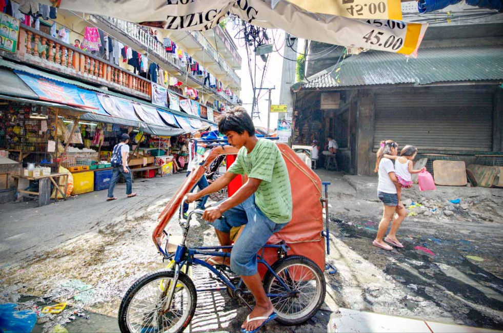 A pedicab driver races through the Baclaran Market in Manila, Philippines