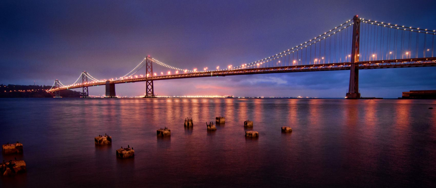 Blue hour over the Bay Bridge, as seen from the San Francisco Embarcadero