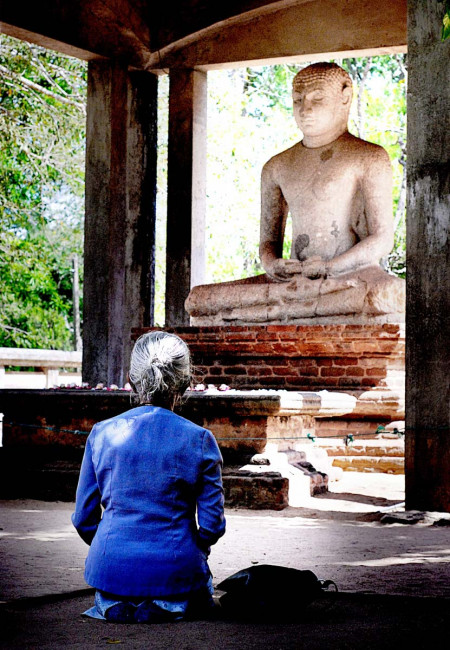 A woman prays to the Samadh Buddha in Anuradhapura - one of the Ancient Cities in Sri Lanka