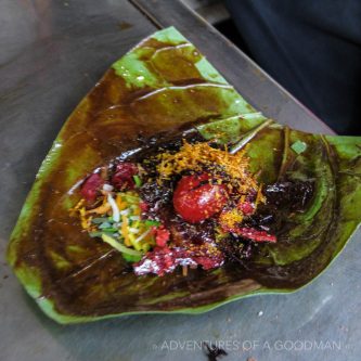 Paan: chopped nuts, a red paste, slaked white lime, a mix of sweet spices and a cherry on top, all wrapped in a triangular shaped leaf.