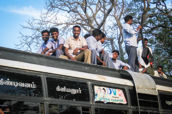 Rooftop bus passengers in India