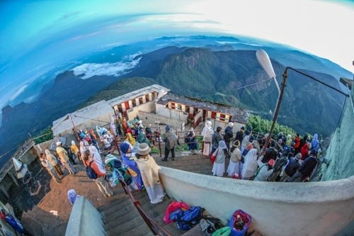 Travelers and devotees greet the dawn from atop Adam's Peak in Sri Lanka