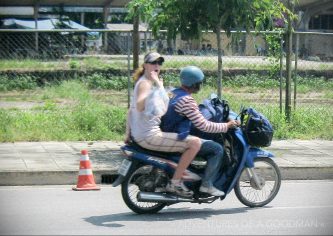 Carrie and her bags on the back of a scooter in Sungai Kolok