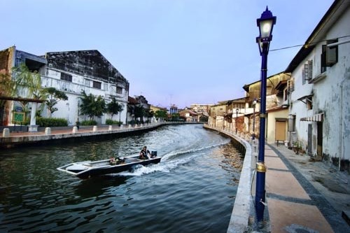 A boat goes down the river in Melaka (Malacca), Malaysia