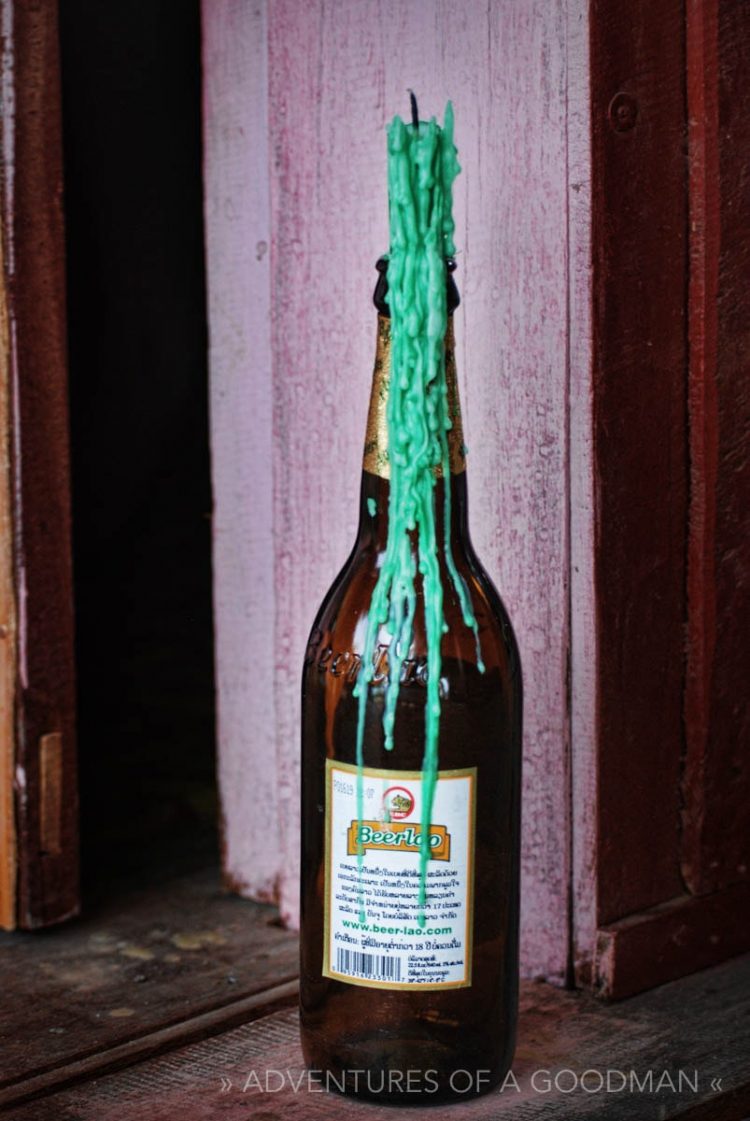 A Beerlao bottle being used as a candle holder