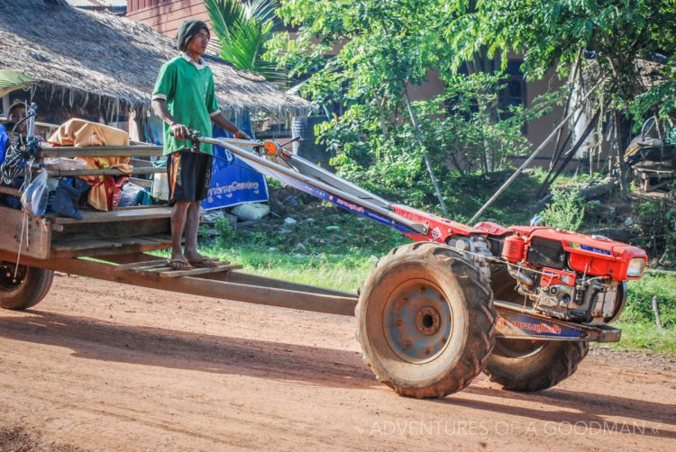 A tractor engine tows a wooden cart in Laos