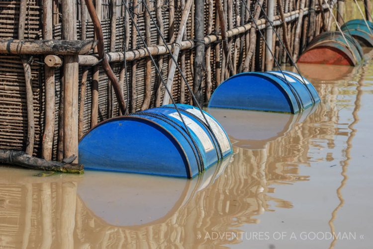 Old oil barrels are used to help keep houses afloat