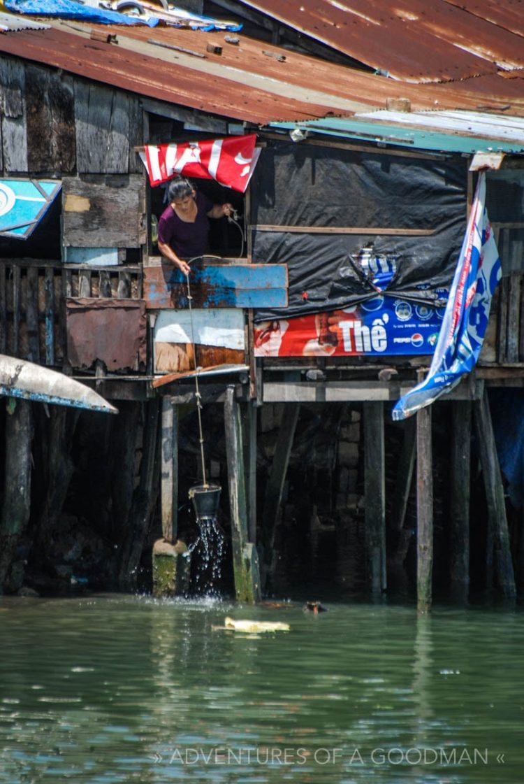 A local scoops water with a bucket in NahTrang, VietNam