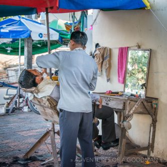 An outdoor barber on the streets of Phnom Penh, Cambodia