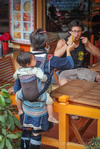 A local tribeswoman sells a musical instrument to a tourist in Sapa