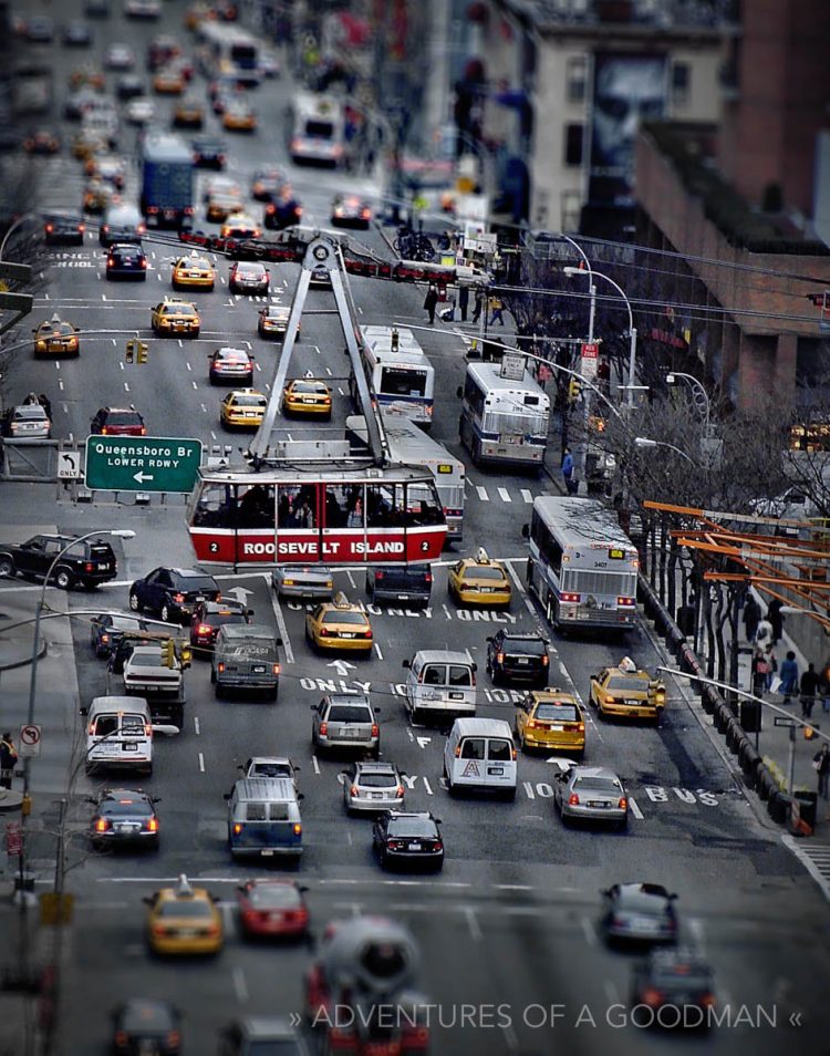 The Roosevelt Island Tram hangs above Manhattan Traffic on 2nd Avenue and 59th Street