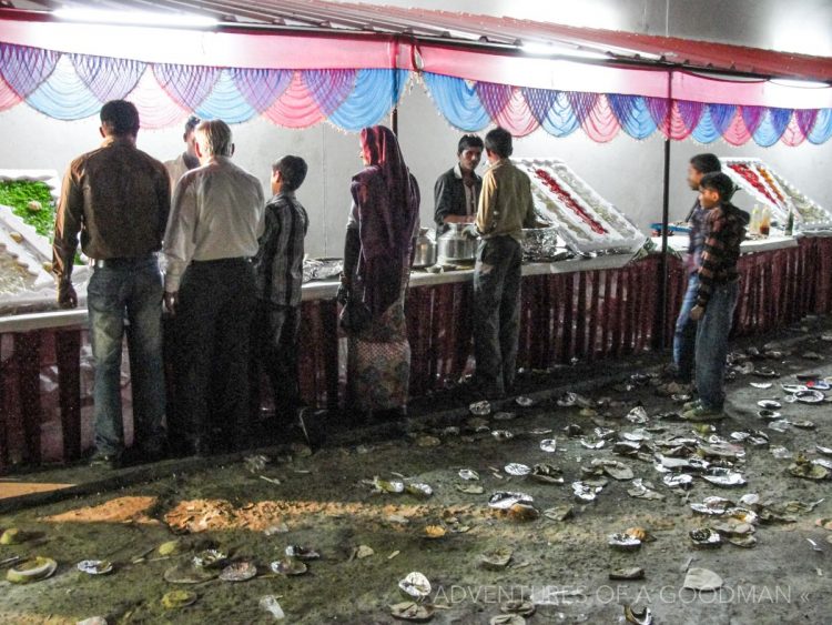 After finishing their food, wedding guests throw their plates on the floor