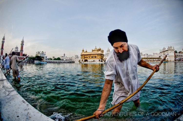 A local Sikh man keeps the Amrit Sarovar clean