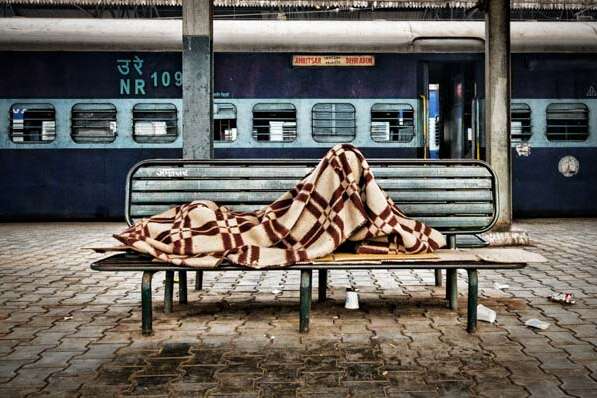 A sleeping passenger waits for his train in the main station in Amritsar, India