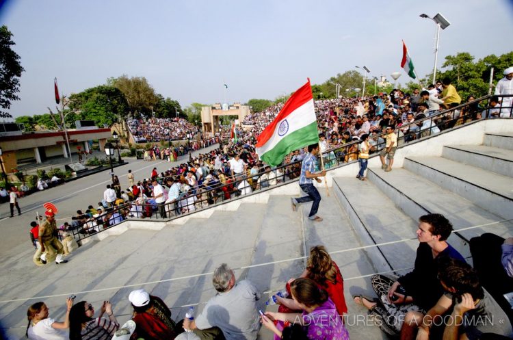 VIPs run around with flags during the pre-Ceremony pep rally at the Pakistan India Sunset Border Celebration