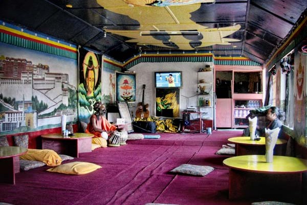 A Baba sits down to play the drums at the Welcome Cafe in Bhagsu, McLeod Ganj, India