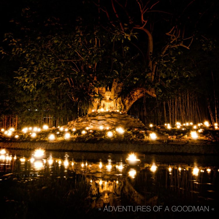 A Buddha statue reflects in a pond at Wat Pan Tao during Asanha Bucha Day in Chiang Mai, Thailand