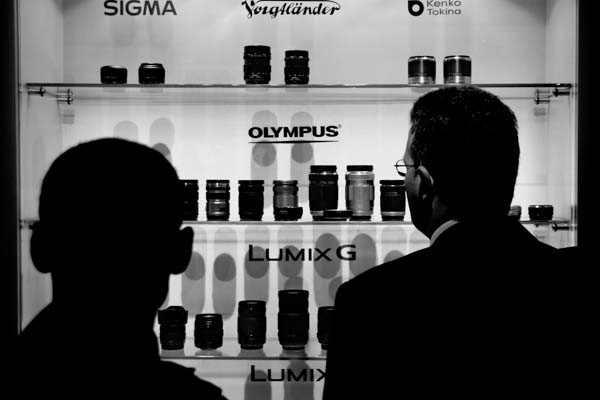 Businessmen take a long look at the lens lineup at the Lumix display