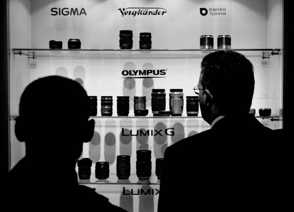 Businessmen take a long look at the lens lineup at the Lumix display