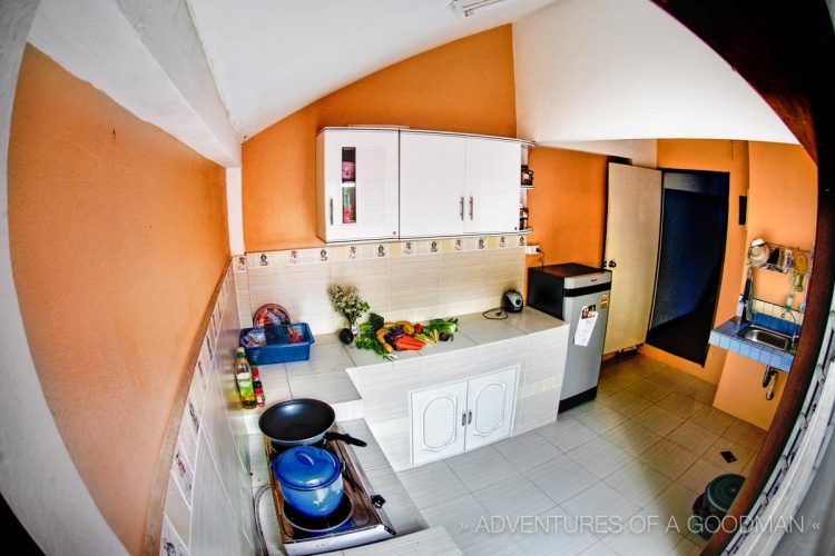 Our kitchen is massive, orange, and great for cooking. It came with a fridge and a gas burner; we had to buy pots, pans, cutlery, and everything else.