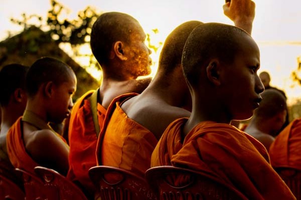 A monk gets the energy of a camera at sunrise - 12,999 monk alms procession in Chiang Mai, Thailand