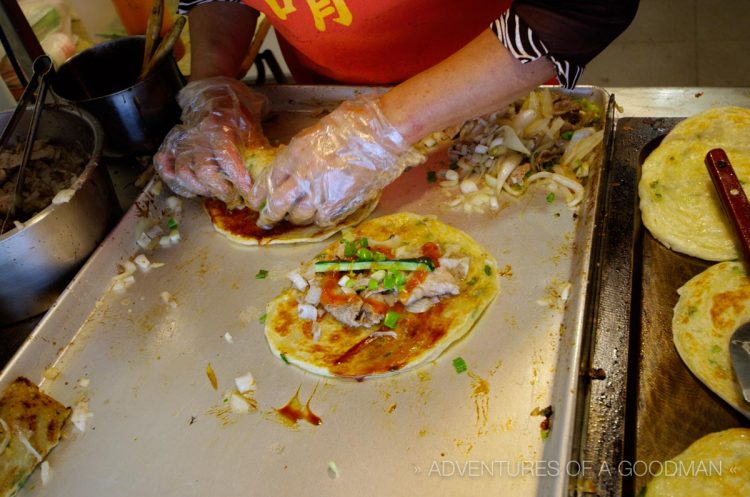 A "burrito" rolled in something like an Indian parotta with , with pork, onion, cucumber and duck sauce