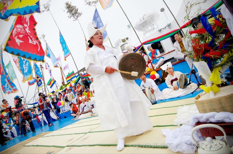 A Mudang bangs a jing while performing a gut