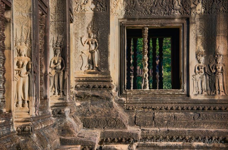 The outer western wall of Angkor Wat is bathed in golden light just after sunrise.