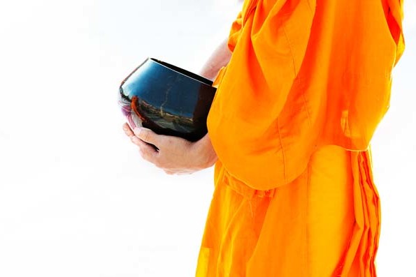 A monk holds an alms bowl during the 12,999 Monk Alms Procession in Chiang Mai, Thailand