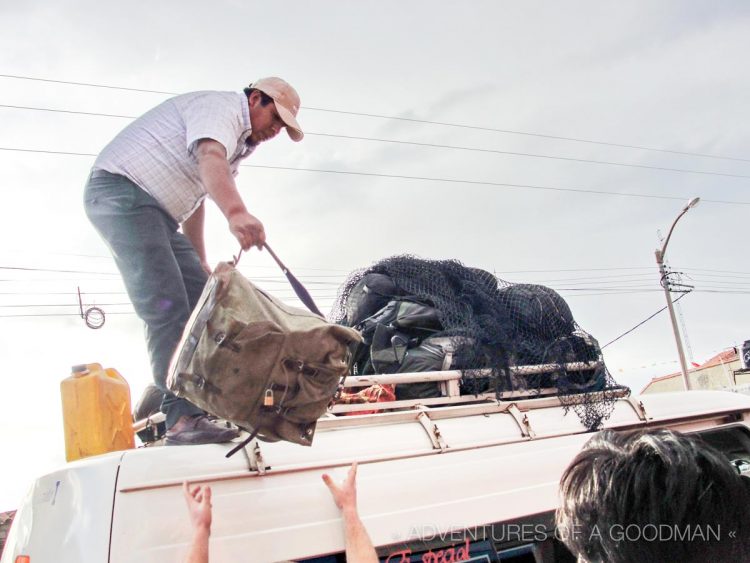 Our original driver removes bags from the roof of our microbus