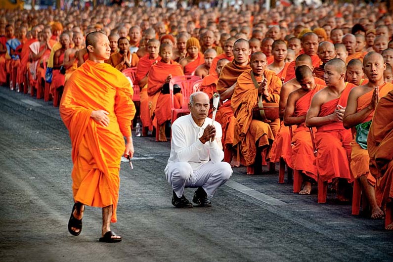A devotee is surrounded by 12,999 monks in Chiang Mai, Thailand