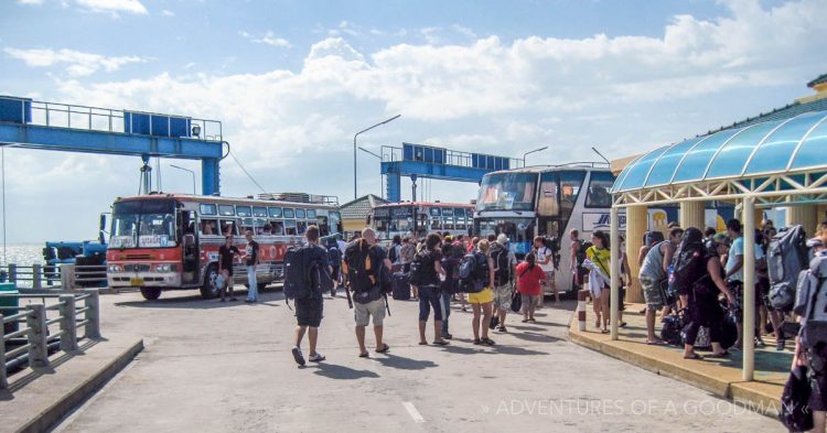 Buses on the side of a dock, waiting to take tourists to the train station.