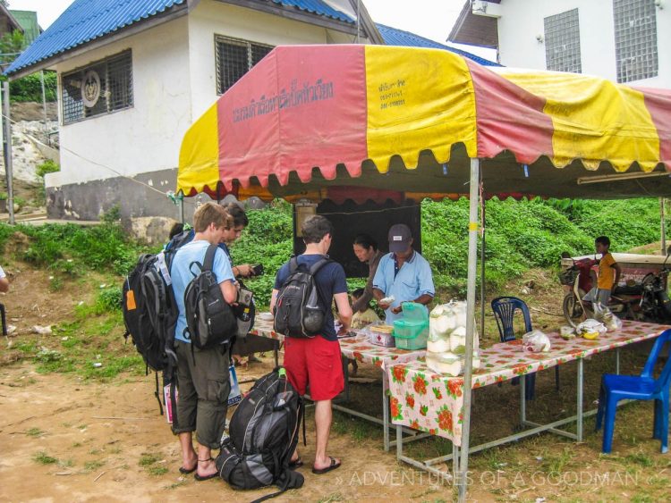 Buying a boat ticket to cross the Mekong River and enter Laos