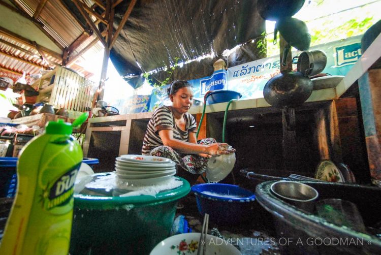 A woman washes dishes at our guesthouse in Champasak, Laos