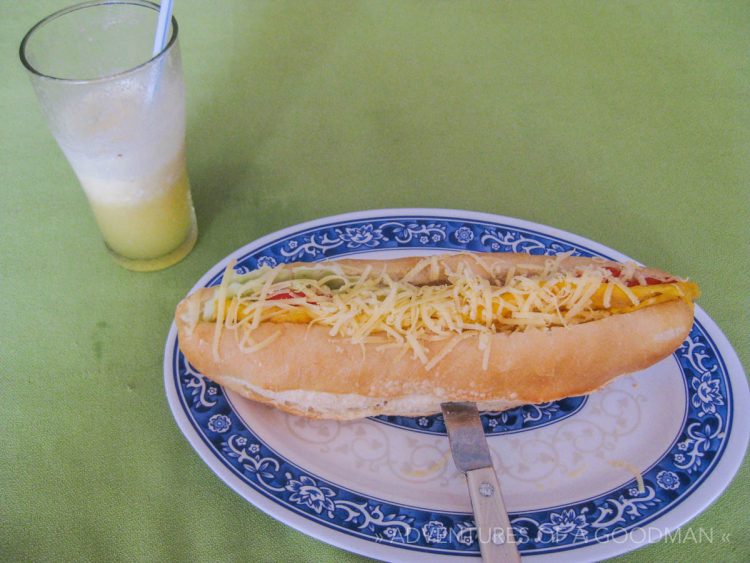 An egg omelette sandwich, covered in cheese — for sale in Vang Viang